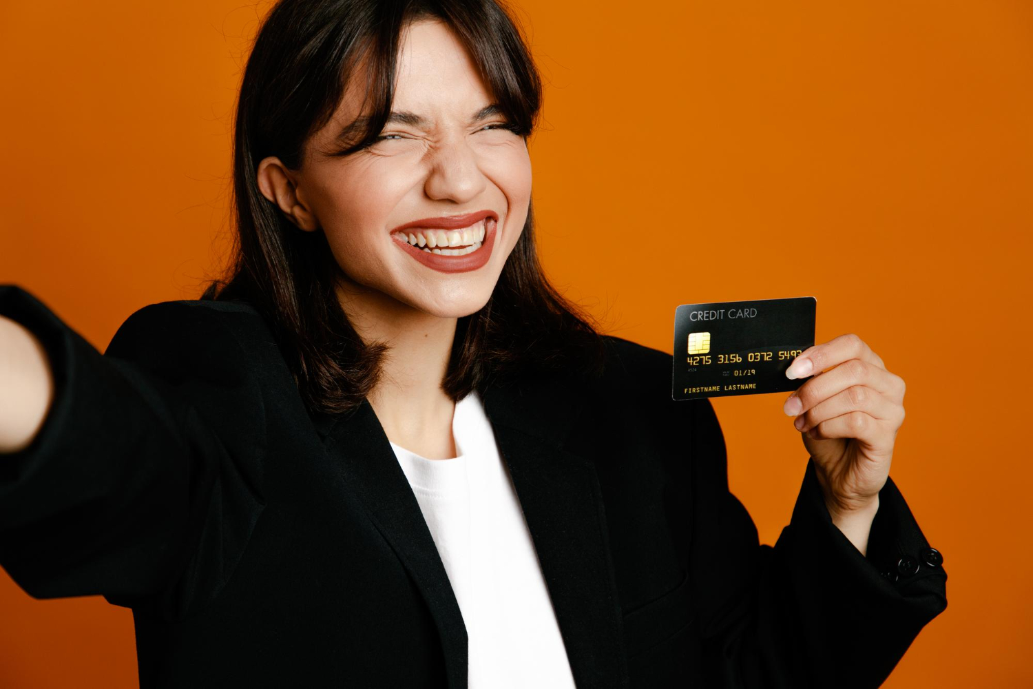 Happy woman holding a Aeroplan Credit Card.