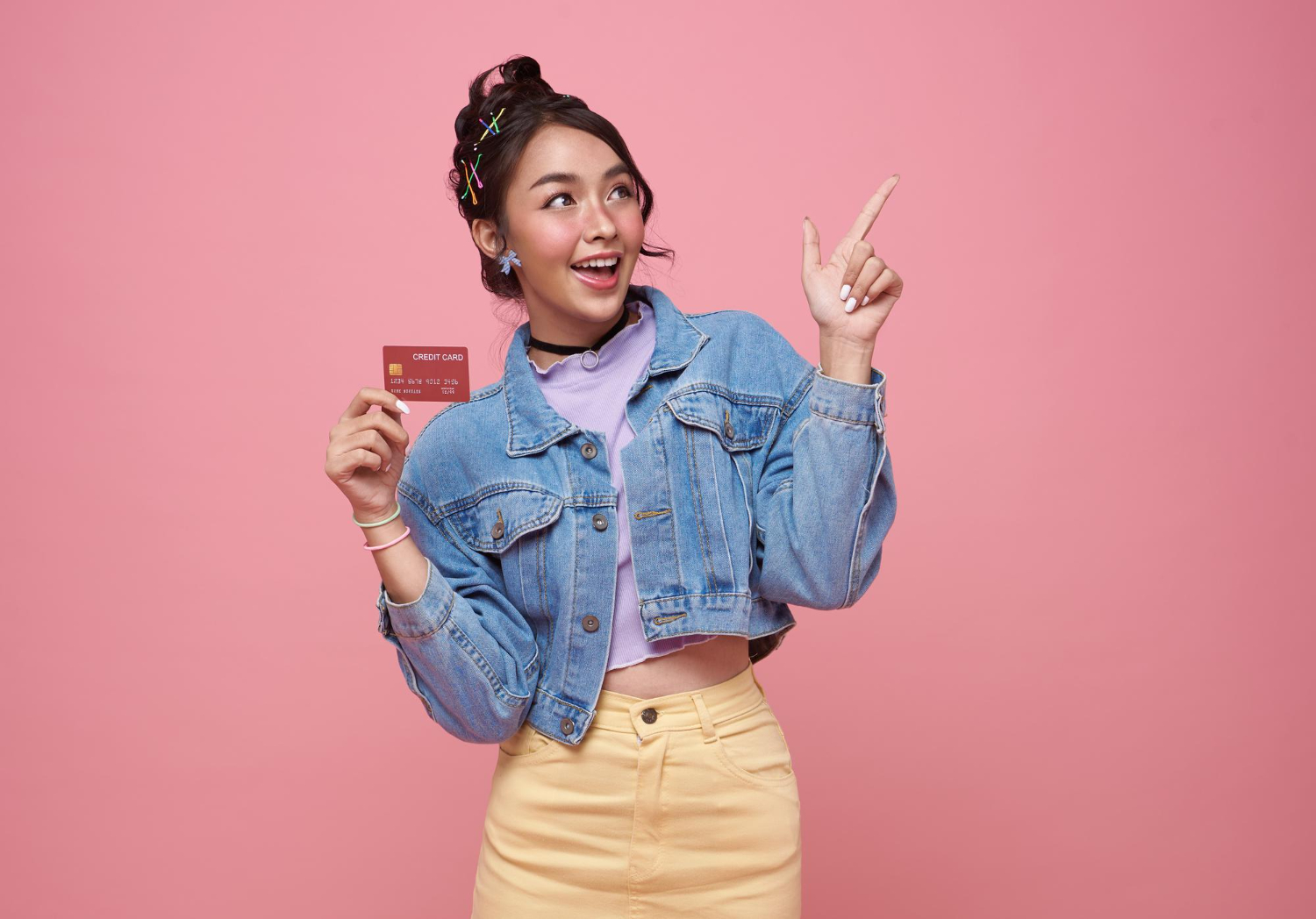 A girl being happy and holding her Student Credit Card.