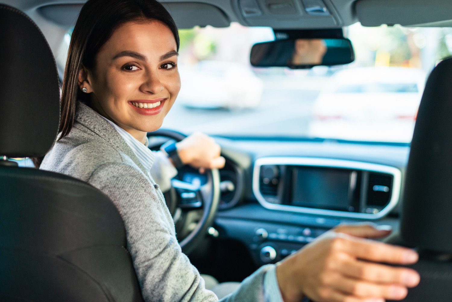 Woman in her car, using an Used Car Insurance while driving.